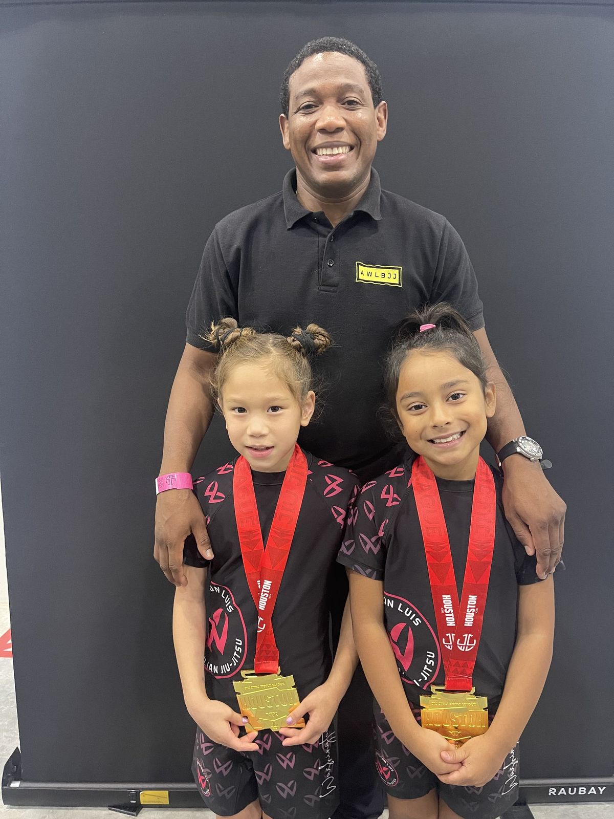 Professor Washington Luis with two junior competitors and their gold medals